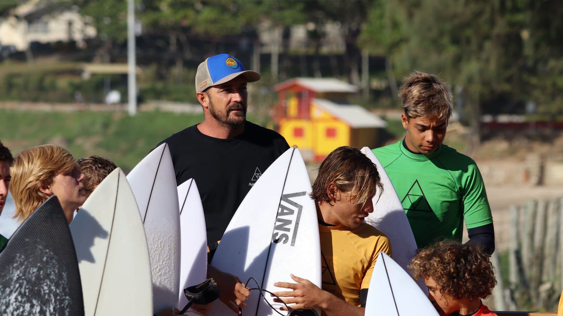 Coach com alunos segurando as pranchas