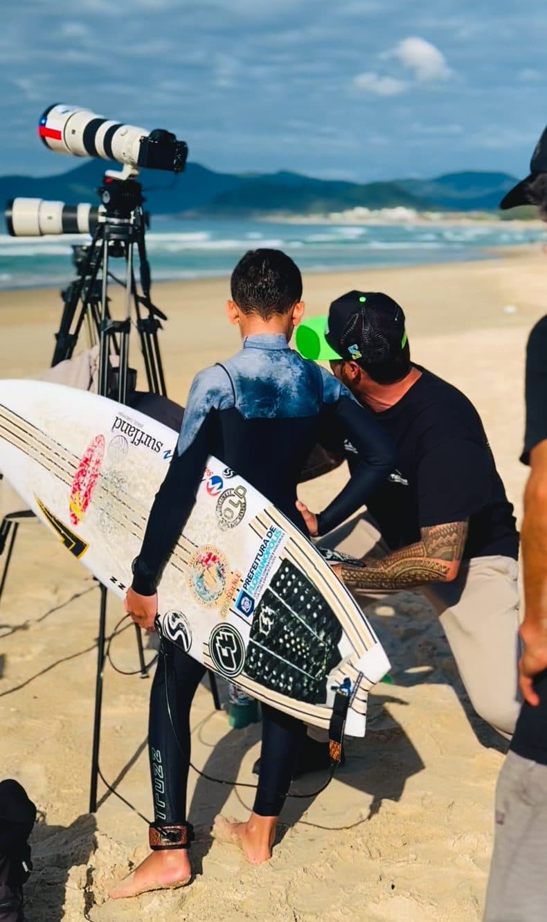Coach orientando um atleta na areia, com as câmeras montadas