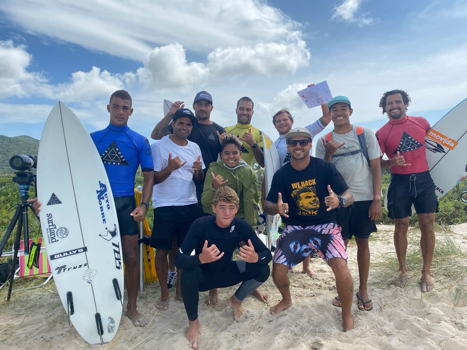 Grupo com pranchas na areia