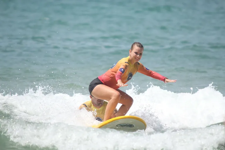 Aluna Isa surfando na sua primeira aula
